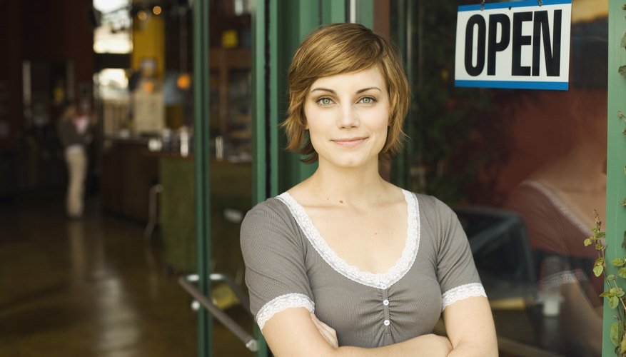 Photo Credit: Jupiterimages/Brand X Pictures/Getty Images employee standing in front of open store
