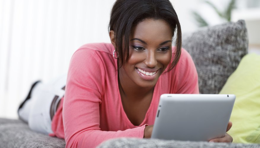 A woman is browsing on her tablet.