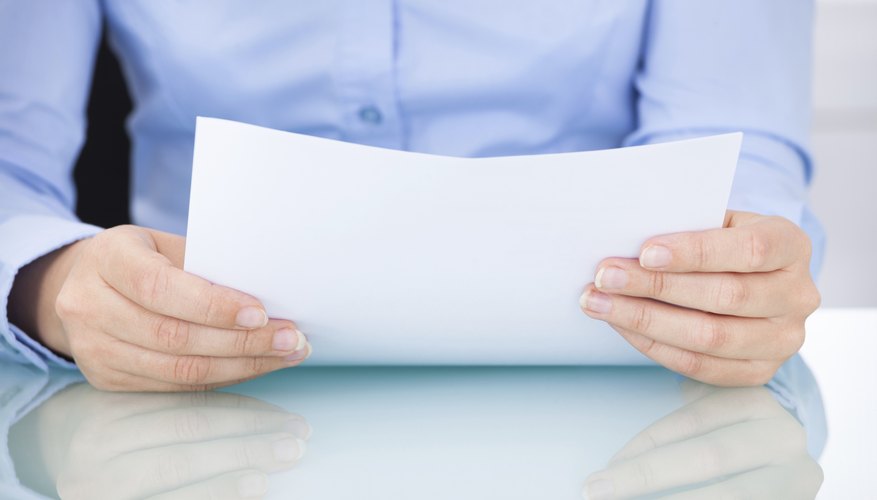 Businesswoman Holding Documents At Desk