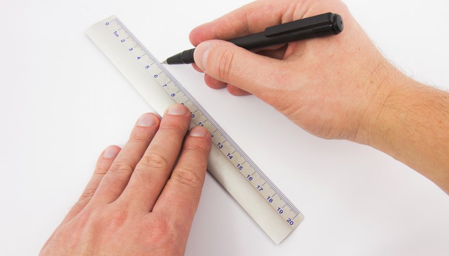 Male hands drawing line with a ruler