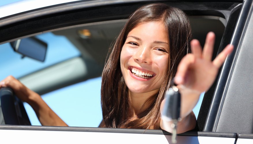 Young woman holding keys to a car. Young woman holding keys to a car.