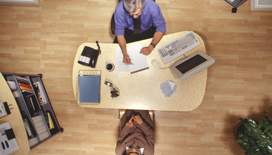 Woman and man working at desk in office, overhead view