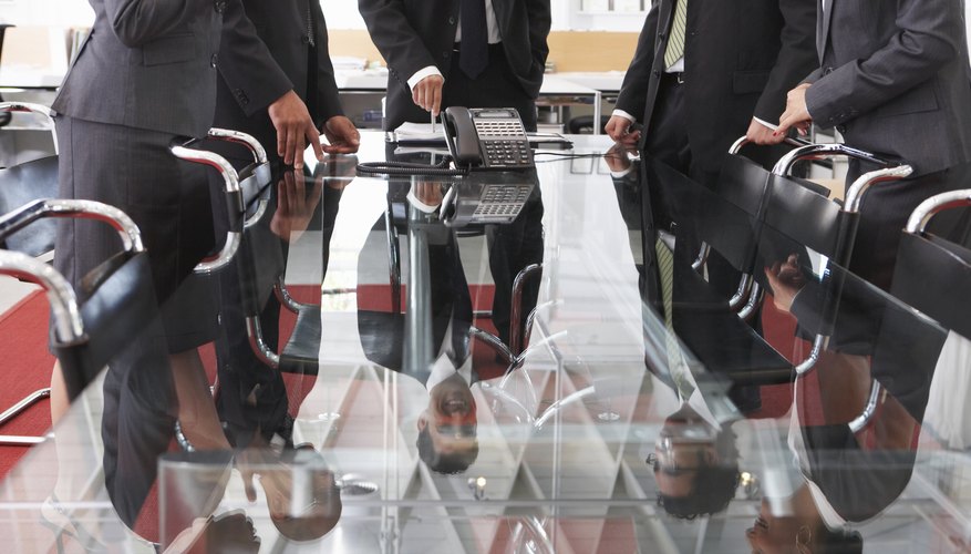 Business men are gathered around a table.
