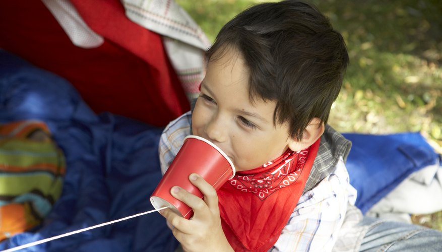 Photo Credit: BananaStock/BananaStock/Getty Images Boy talking on a string phone