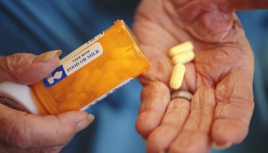 Photo Credit: Steve Mason/Photodisc/Getty Images Senior woman putting pills in her hand.