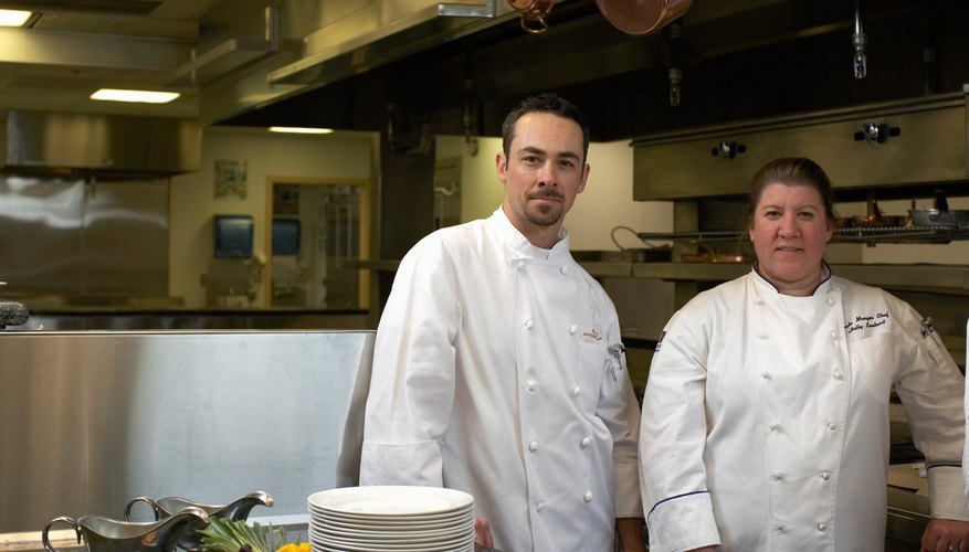 Portrait of male and female chef in commercial kitchen