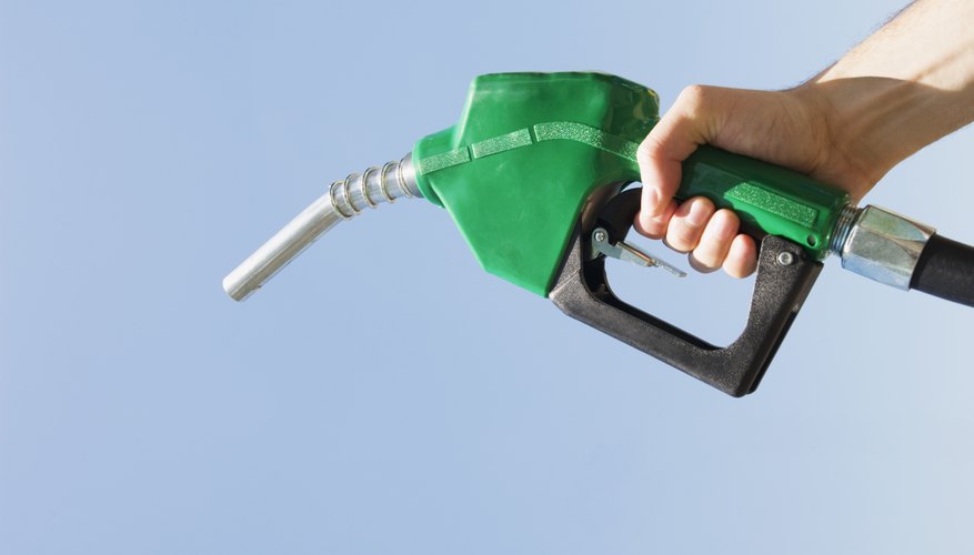 Hand holding green fuel pump nozzle