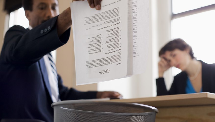Businessman throwing away report into trash