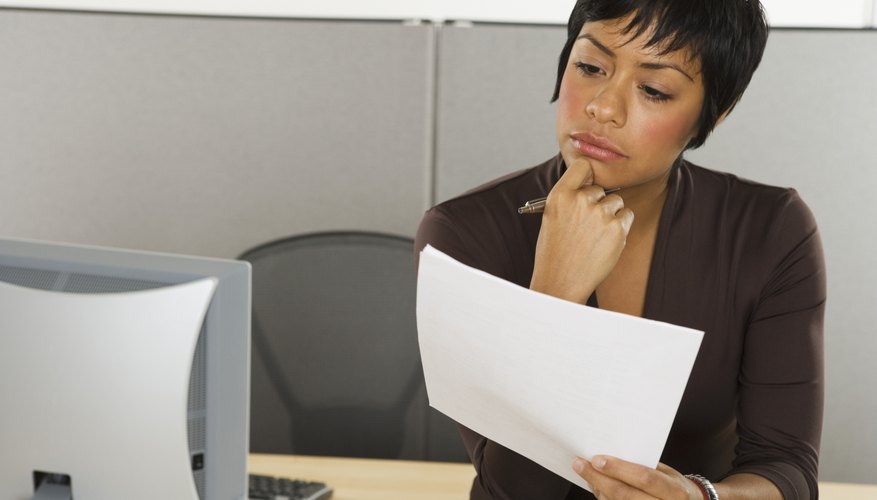 Businesswoman reading papers at desk