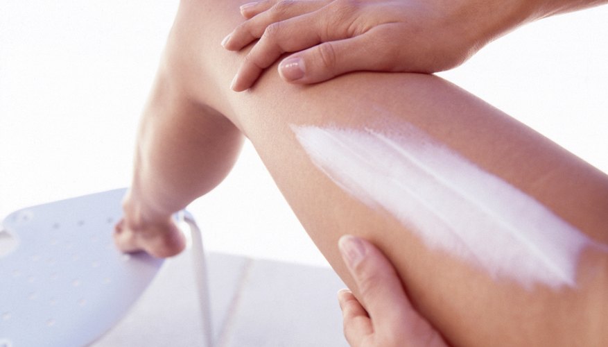 woman putting cream on leg woman putting cream on leg