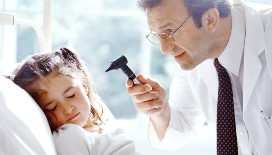 Doctor looking at child's ear in hospital Doctor looking at child's ear in hospital