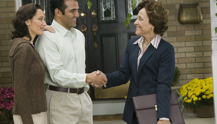 Couple shaking hands with real estate agent.