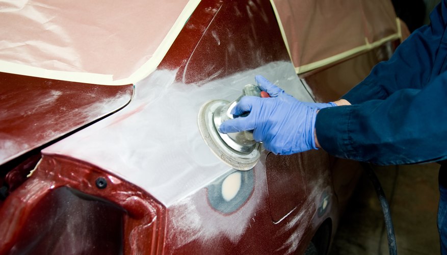 Mechanic polishing automobile in body shop
