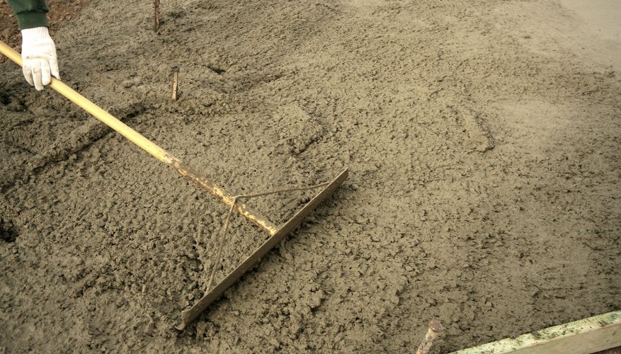 Photo Credit: Calman Lugo/iStock/Getty Images A close-up of a worker laying a concrete driveway.