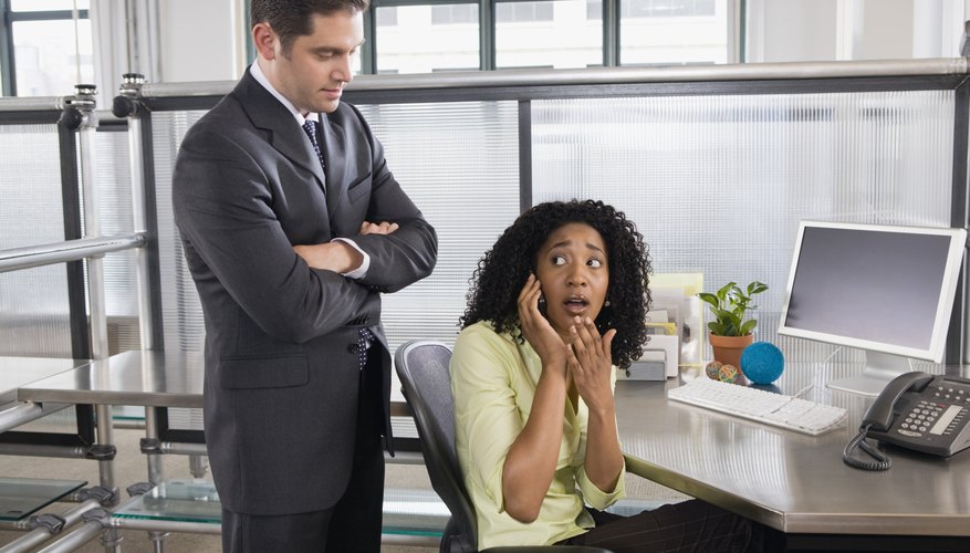 Boss catching businesswoman using cell phone