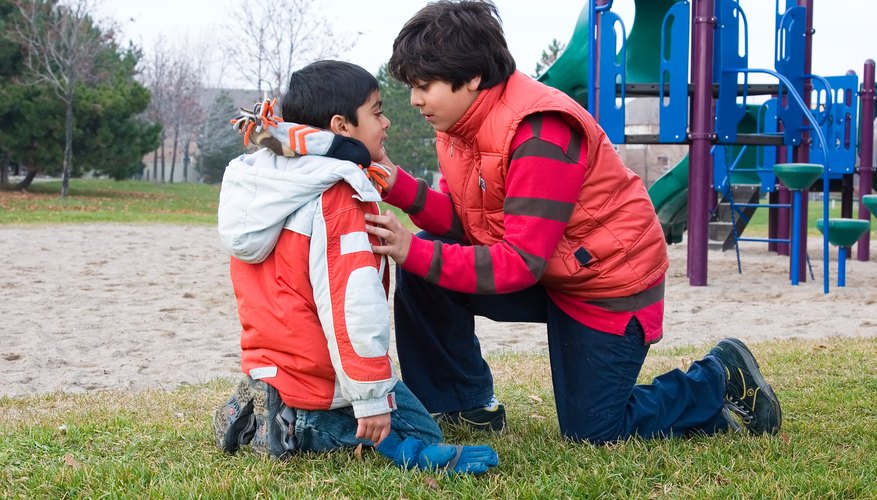 Boy taking care of his younger brother at playground Boy taking care of his younger brother at playground