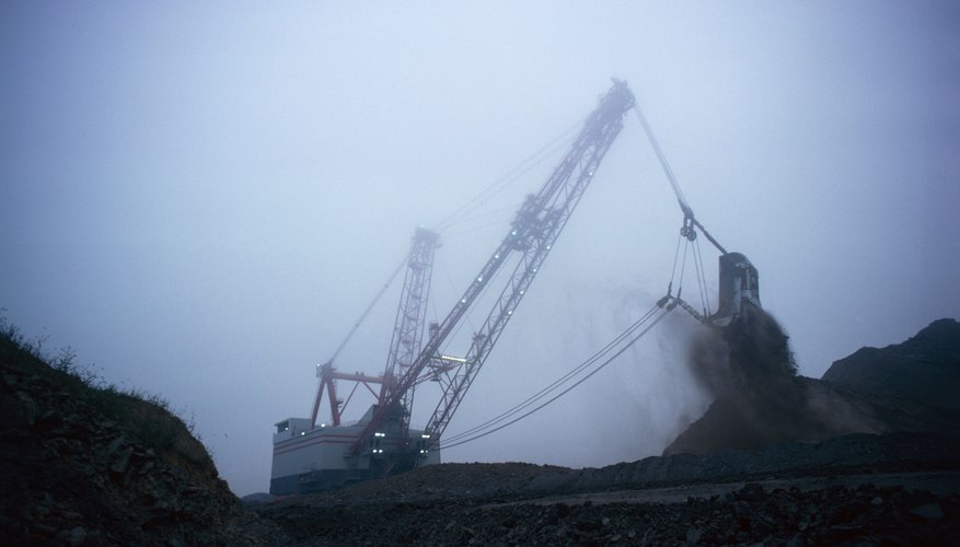 Excavaters remove coal from a mine. Excavaters remove coal from a mine.