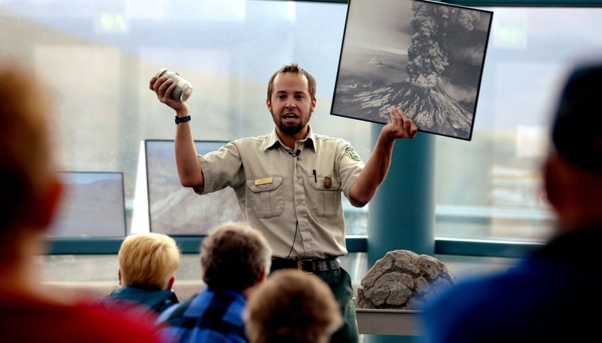 Photo Credit: Craig Mitchelldyer/Getty Images News/Getty Images A guide holds up a photo from the 1980 eruption of Mt. St. Helen's