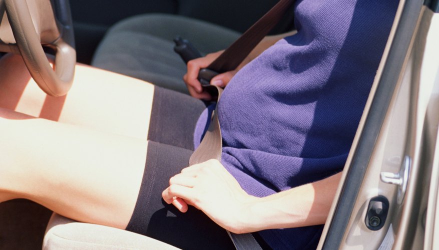 Pregnant woman adjusting seatbelt