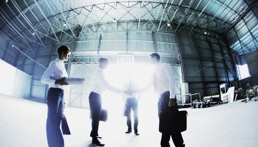 Businesspeople shaking hands in warehouse