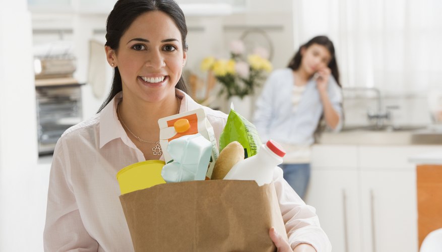 A woman is bringing her groceries into the house.