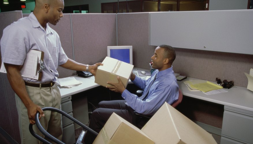 Photo Credit: Purestock/Purestock/Getty Images A delivery man handing a parcel to an office employee.