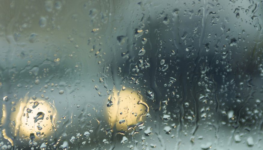 Car headlights through rainy window
