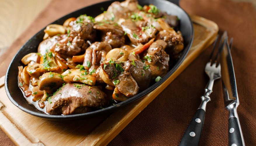 Liver baked with mushrooms and herbs in a cast iron pan. Liver baked with mushrooms and herbs in a cast iron pan.