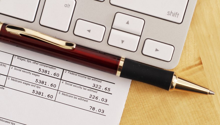 A keyboard and tax form on a desk.