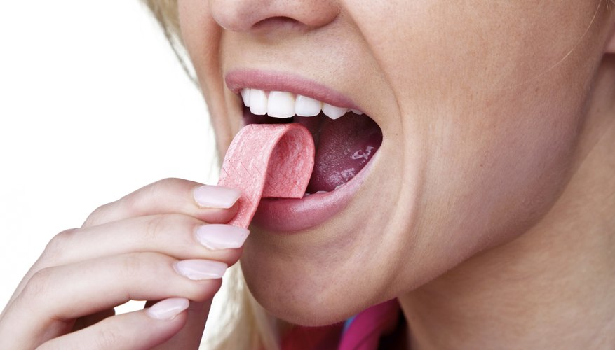 Woman putting chewing gum in her mouth Woman putting chewing gum in her mouth