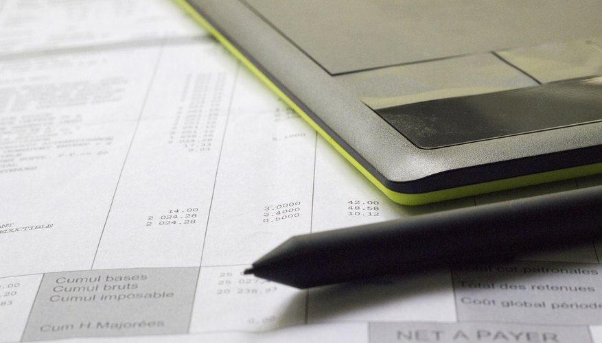 A calculator and pen are sitting on top of a credit report.