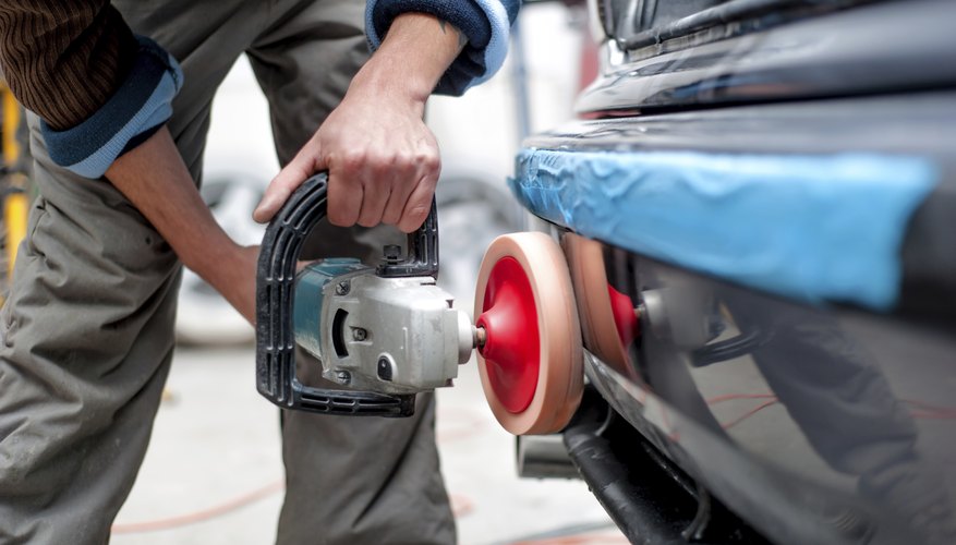 A man is buffing out scrapes on a car.