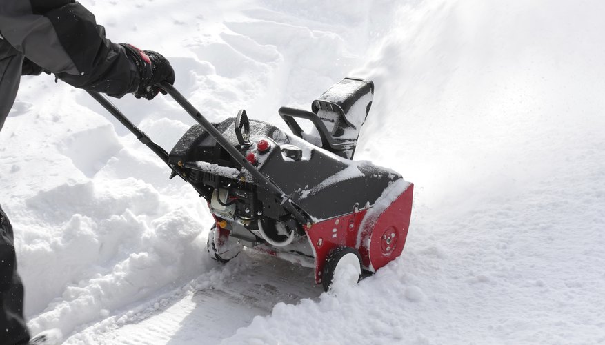 Photo Credit: Grzegorz Kieca/iStock/Getty Images A snow blower clearing a path.