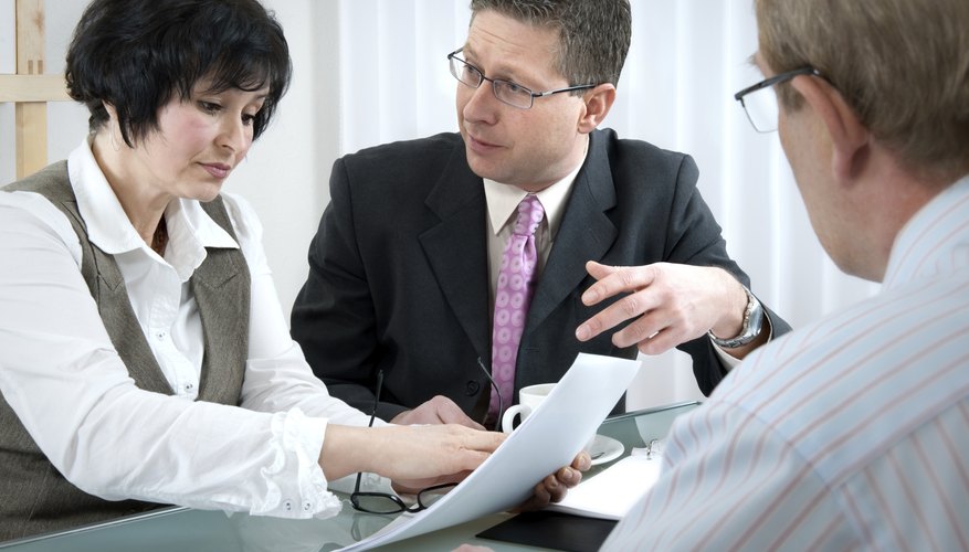 A lawyer discusses legal matters with two clients