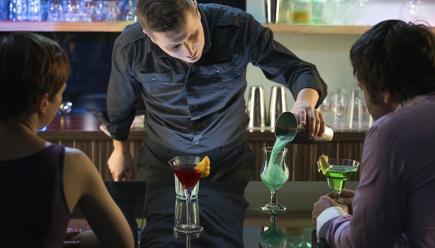 Photo Credit: Tashi-Delek/iStock/Getty Images A bartender pouring drinks.