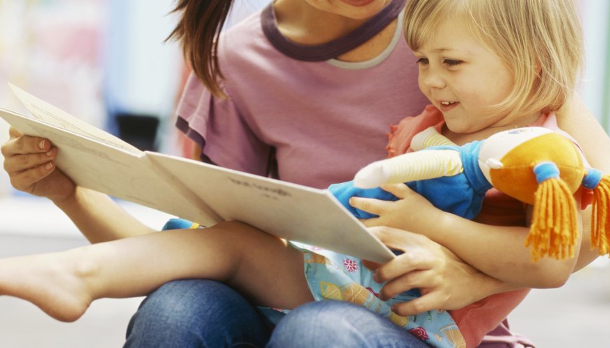 A young woman reads to a toddler at a day care center A young woman reads to a toddler at a day care center