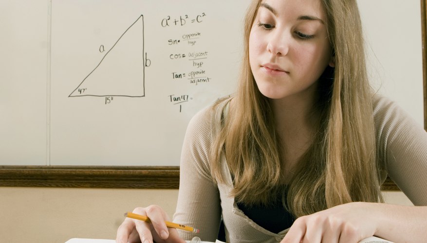 A student working with a calculator in a classroom. A student working with a calculator in a classroom.