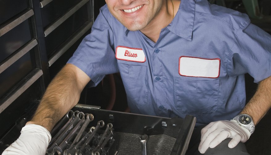 Smiling mechanic with wrenches