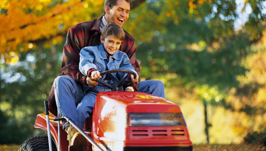 Father and son on tractor mower