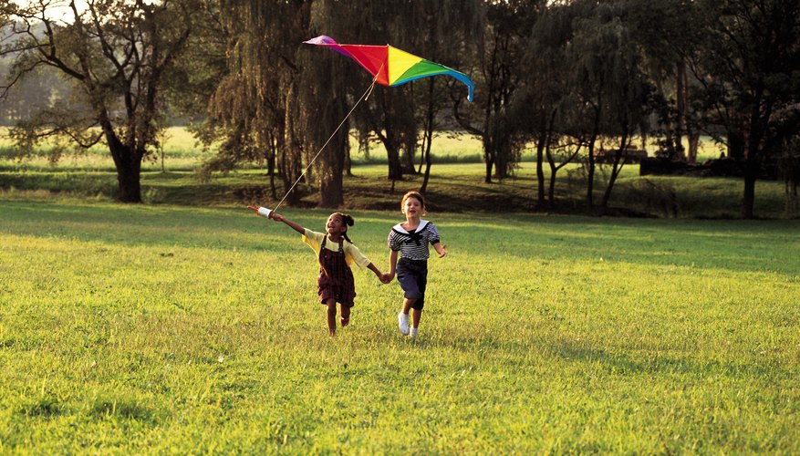 Photo Credit: Comstock/Stockbyte/Getty Images Two girls flying a kite in a field.