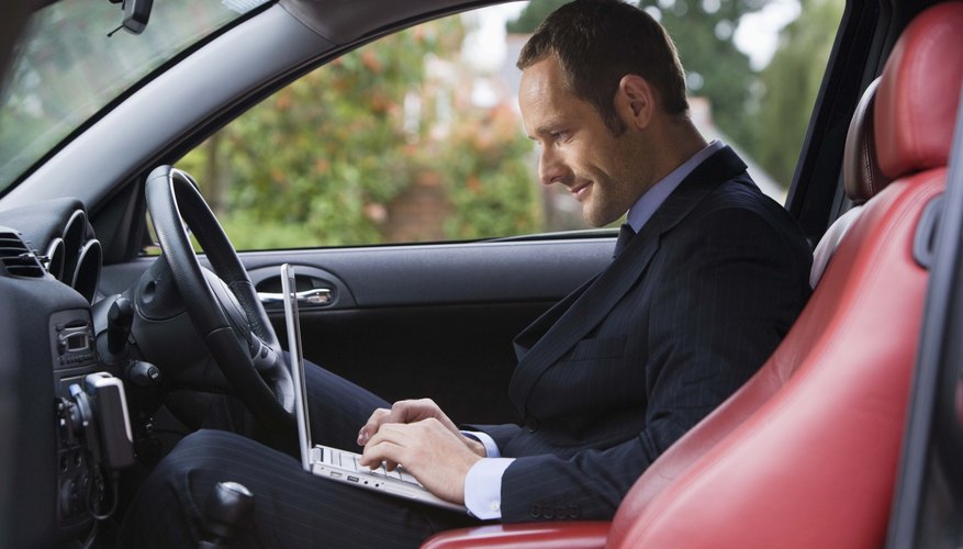 Man inside car on laptop