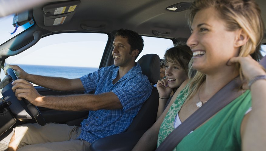 Smiling family riding in minivan