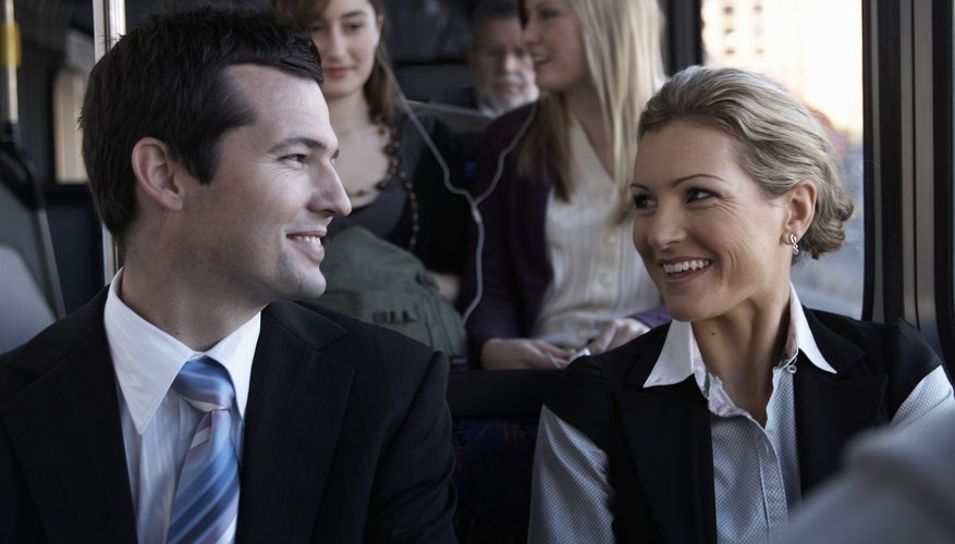 A woman smiles at a man on the train. A woman smiles at a man on the train.