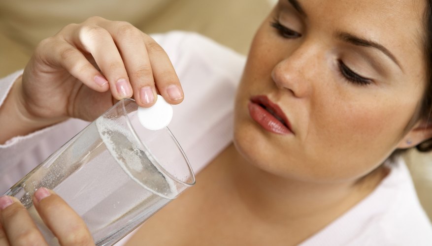 Placing antacid tablet into water glass Placing antacid tablet into water glass