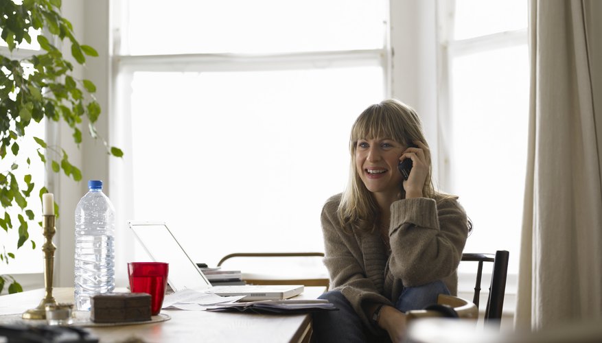 Photo Credit: John Howard/Photodisc/Getty Images A woman on the phone in her home office.