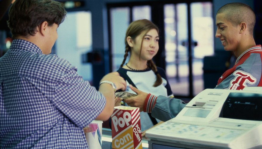 Teen selling popcorn at a movie theater Teen selling popcorn at a movie theater