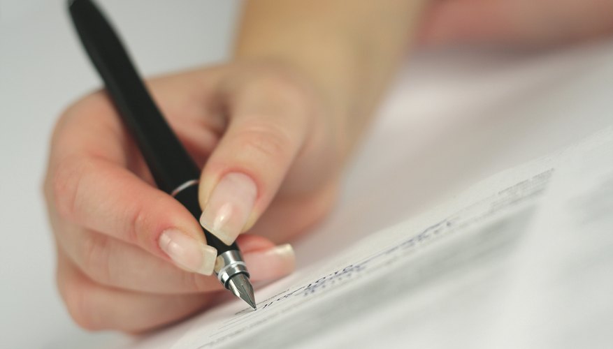 A woman is signing a contract.