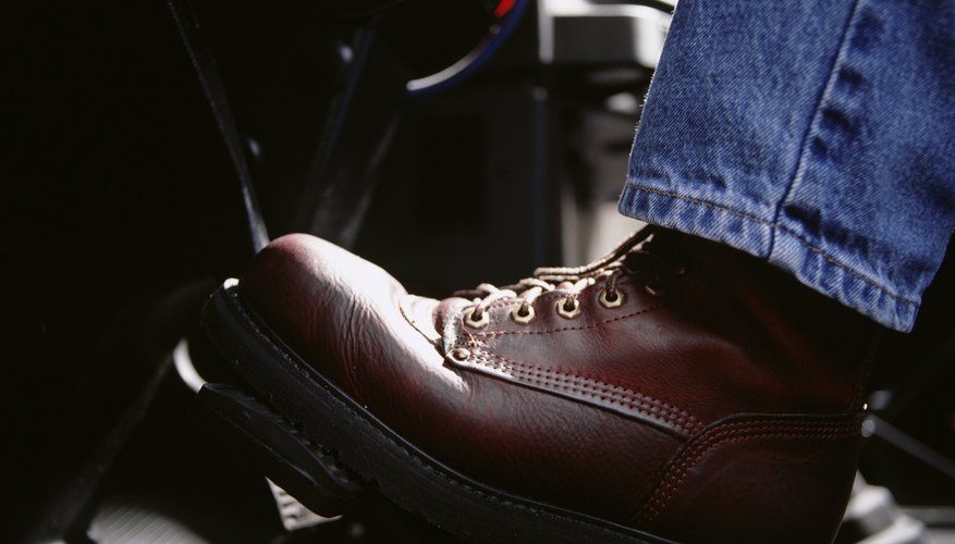 Man pressing car pedal, close-up, low section