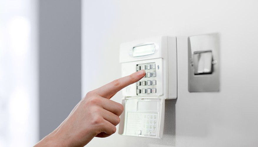 Woman setting burglar alarm