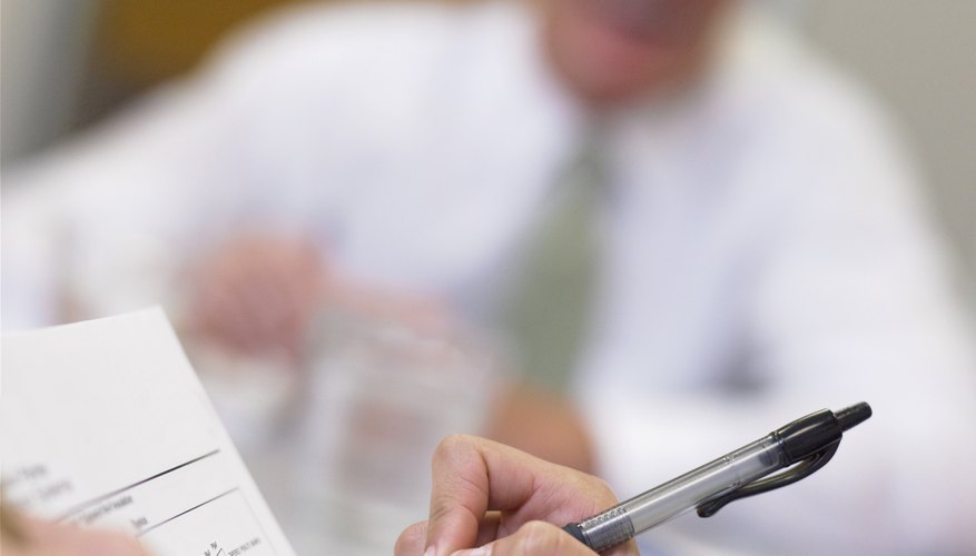 Businessperson writing on paperwork